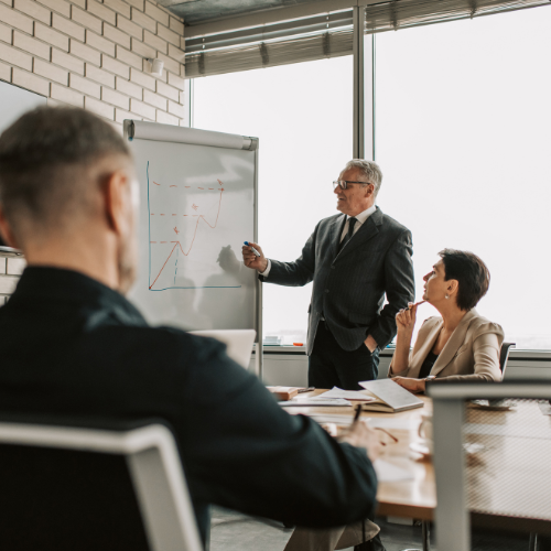 Directivos en reunión de estrategia y toma de decisiones en sala de juntas de Madrid Teach School.